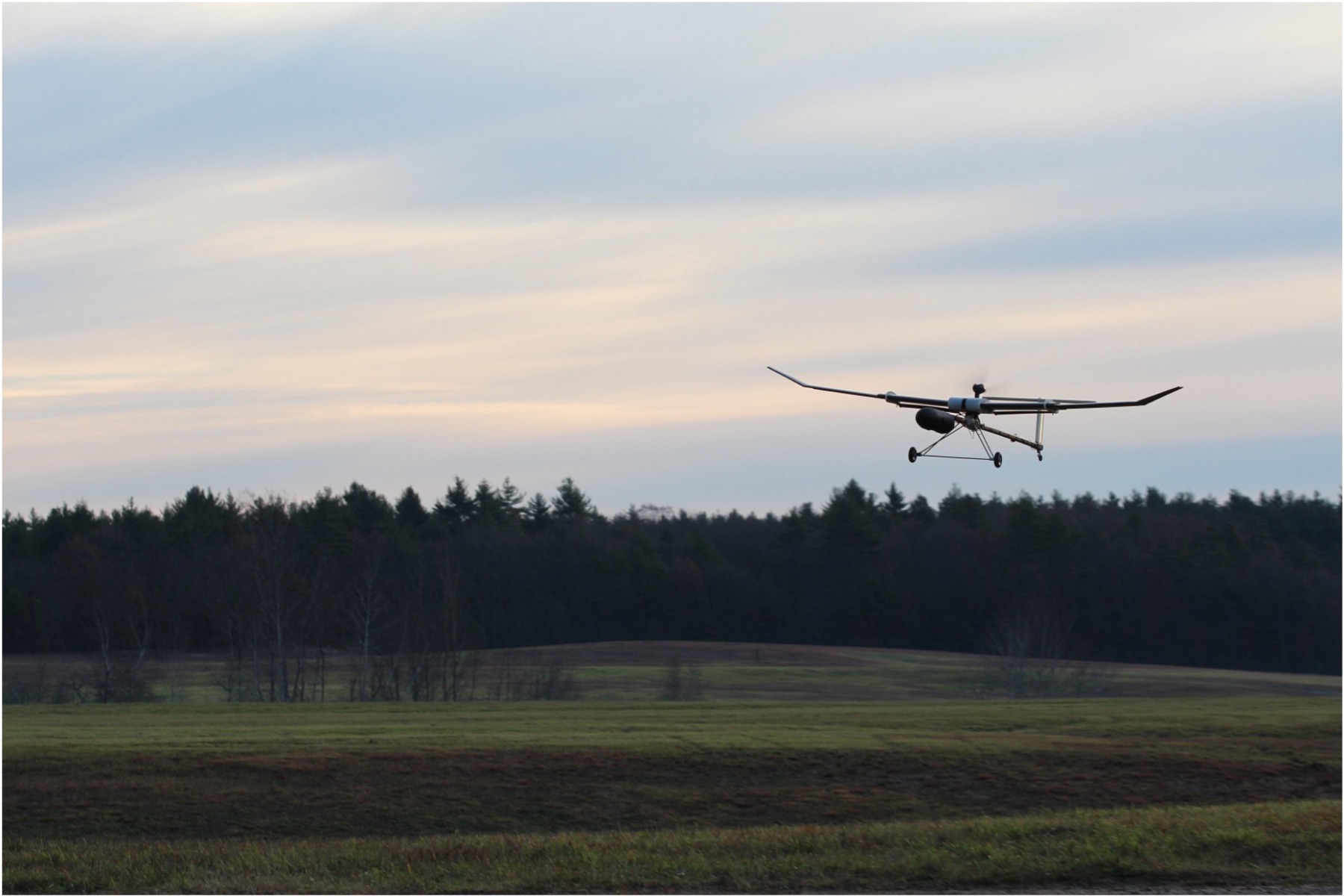 The VAST telescoping UAV in flight over a field, wings fully extended